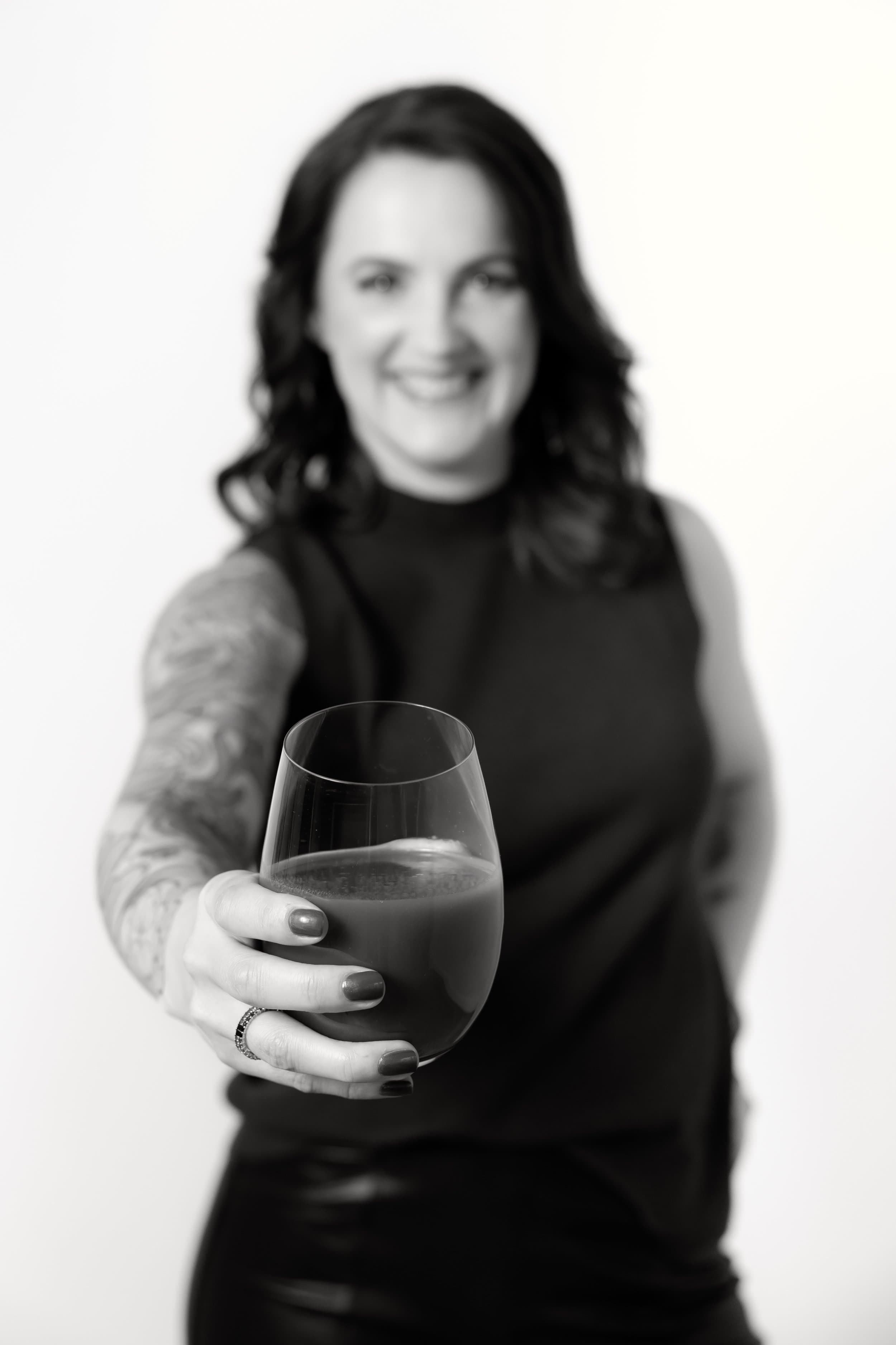 Hand, die ein Glas Tomatensaft entgegenhält